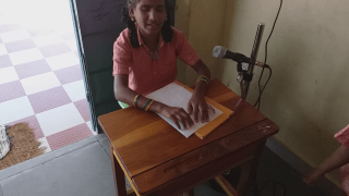 graphic பள்ளியின் வழிபாட்டுக் கூட்டத்தில் பிரெயிலில் செய்தி வாசிக்கும் மாணவி