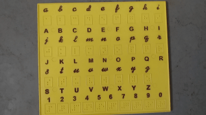 பிரெயில் மற்றும் அச்சு வடிவில் ஆங்கில எழுத்துகள் பொறிக்கப்பட்ட பலகை